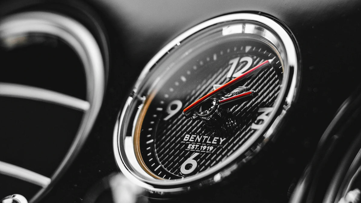 Close-up of a Bentley dashboard clock with a red second hand